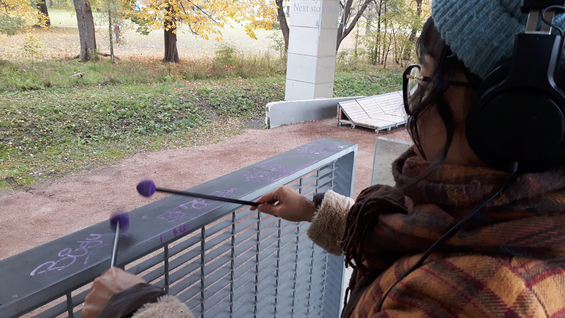 Germaine Liu has two drum sticks in hand and is banking them against the a railing at The Bentway.